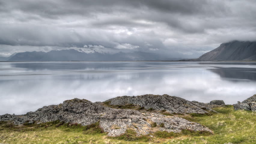 HD video of timelapse clouds at over a mountain range and fjord in Iceland. HDR, HD timelapse video