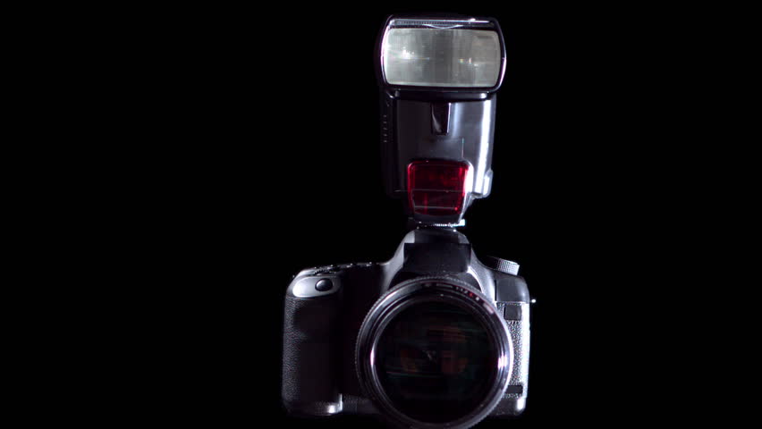 Camera with flash taking a picture on black background