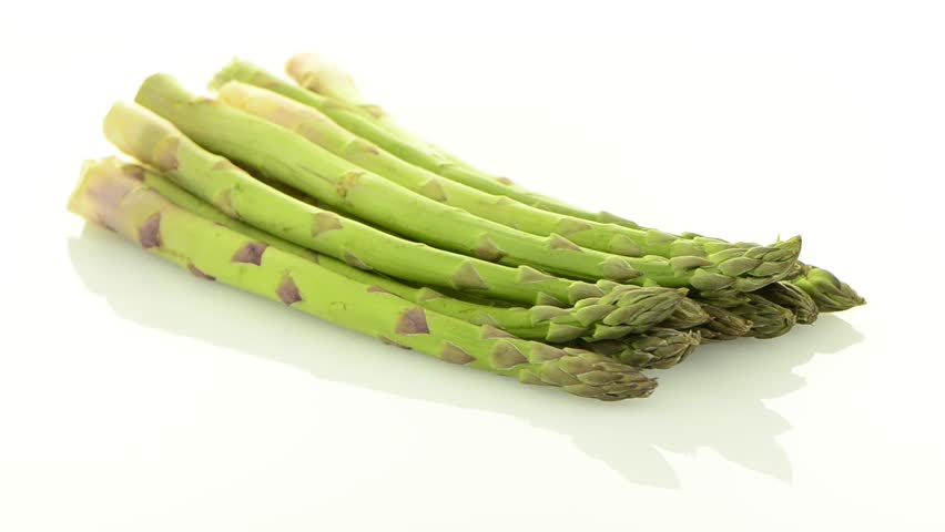 Rotating fresh green asparagus isolated on white background.