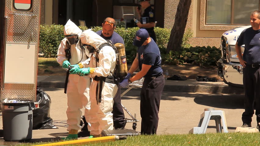 MISSISSAUGA, CANADA - JULY 1 2012: Police in hazardous materials suits working outside an apartment building in Mississauga, Ontario, Canada where a "suspicious death" has occurred.