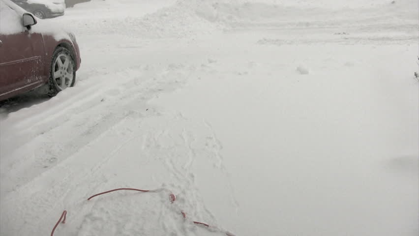 woman snowblowing deiveway with electric shovel