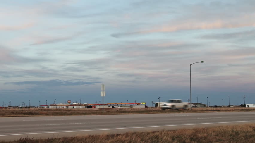 Semi truck on Interstate Highway at dusk. HD 1080p tracking shot.