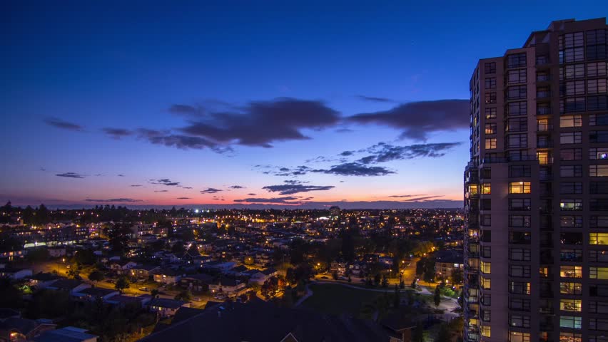 Time Lapse Lighten Up the city in a Residential Area with Houses and Apartment. Night sky changing from Clouds to clear starry night. Shot in 4k RAW photo sequence.