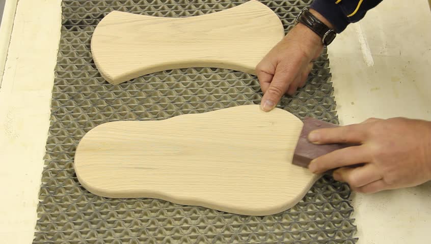 woodworker finish sanding two boards by hand 