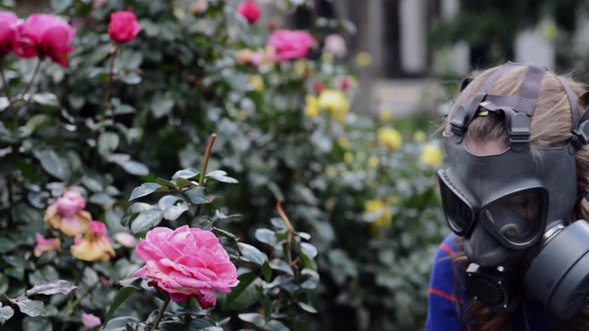 girl in gas mask smells roses