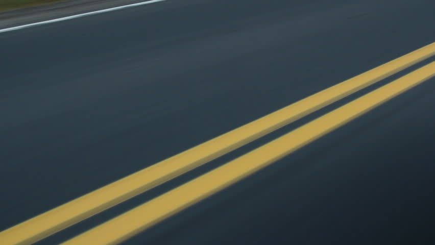 Double yellow lines on the road. Car passes. Ontario, Canada.
