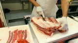 Butcher shop Butcher man hand cutting raw meat with meat chopper. 