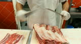Butcher shop Butcher man hand cutting raw meat with meat chopper. 