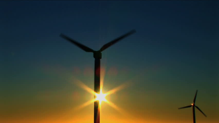 Wind turbines against a blue sky at sunset