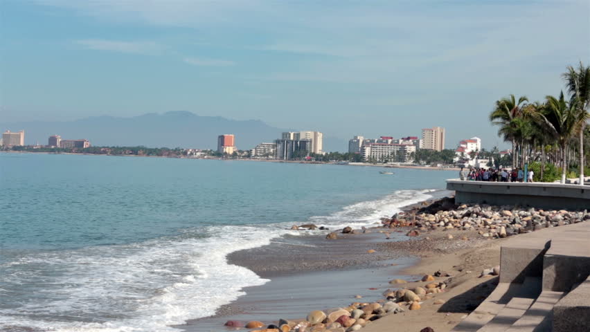 PUERTO VALLARTA, MEXICO NOV 2012: Tourism income. Boardwalk Malecon beach and tourist area shore Banderas Bay, Pacific Ocean. Friends and family stroll and walk along sea shore, restaurants and cafes.