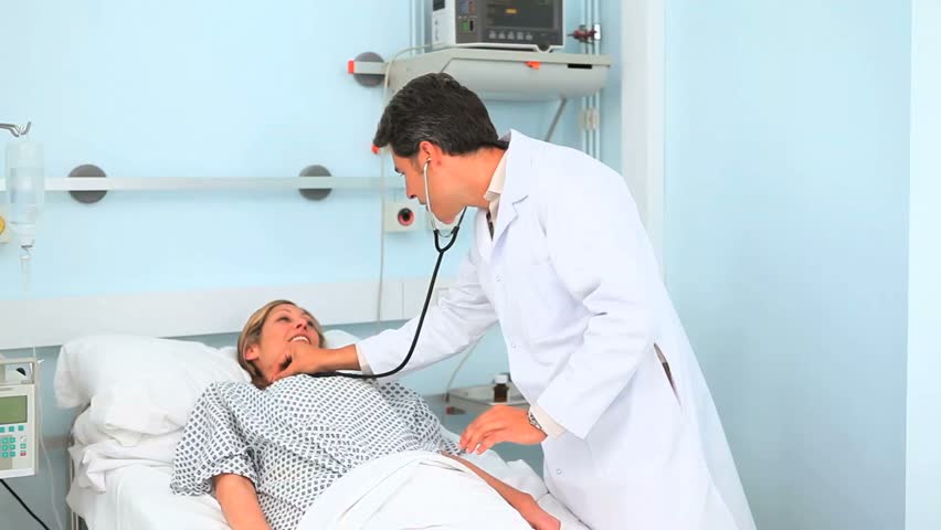 Doctor and patient smiling in hospital ward