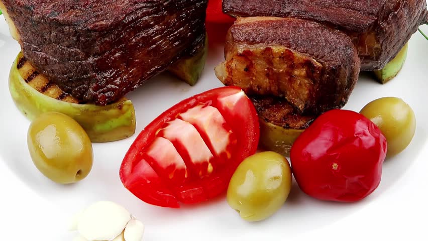 meat savory : beef fillet mignon grilled and garnished with baked apples tomatoes and juice on wooden table