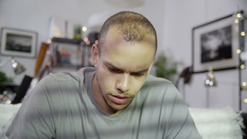 A young man becomes increasingly stressed and depressed over his financial accounts. In slow motion.
