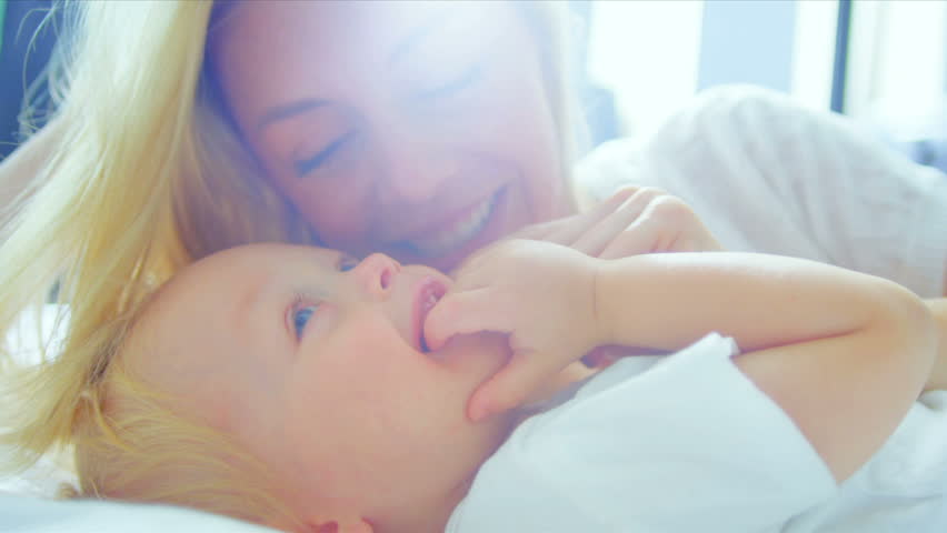 Blonde Mom Holding Young Child Bedroom