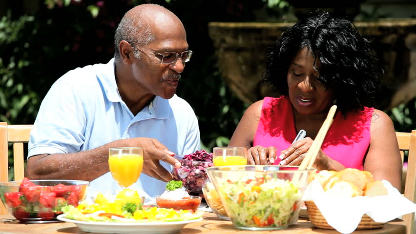 Retired ethnic couple sharing a healthy lunch