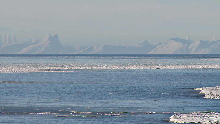 Long shot of the Aleutian Range across the icy Cook Inlet from Bishop's Beach in Homer, AK. 