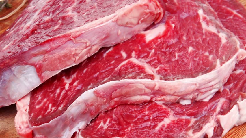 fresh raw beef meat fillet flesh with peppercorn and thyme ready to grill on wood figured old style board isolated over white background