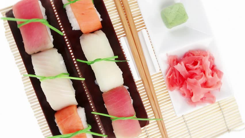 Japanese traditional cuisine - Set of Tuna (maguro) Salmon (sake) and Eel (unagi) Nigiri Sushi with Wasabi and Ginger on bamboo mat isolated over white background