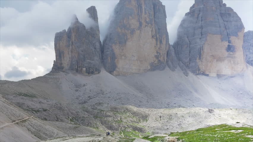Couple of hikers in front a huge mountain complex
