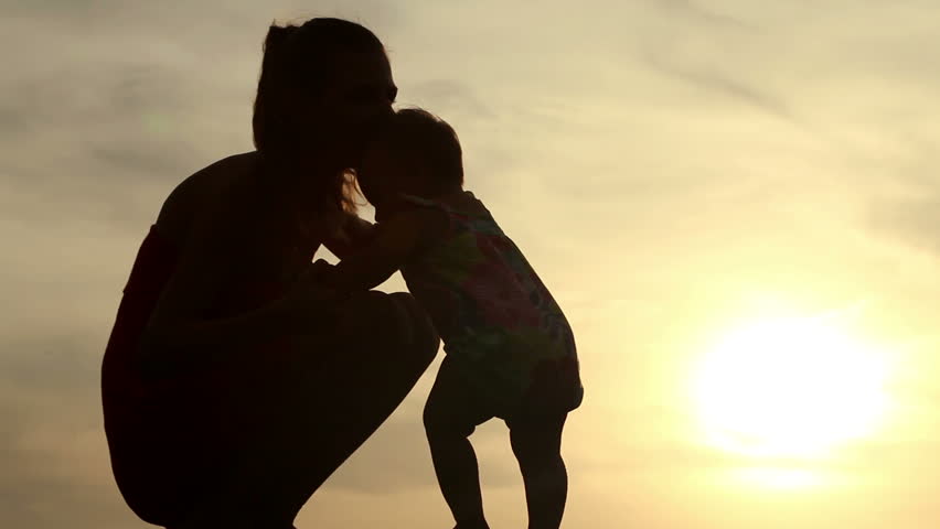 young mom nursing her baby in sunset light