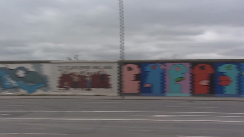 EAST SIDE GALLERY, BERLIN WALL, BERLIN - CIRCA 2002: panoramic shot.  Paintings by artists from all over the world cover this memorial for freedom and make it the largest open air gallery in the world