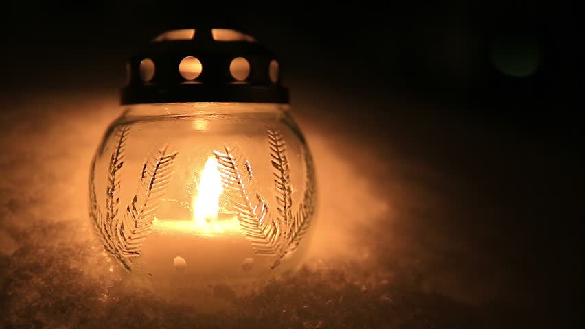 Christmas candle glass light in winter snow in night darkness background