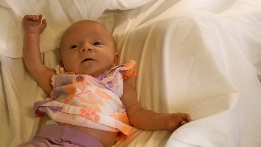 A beautiful one month old baby sneezes