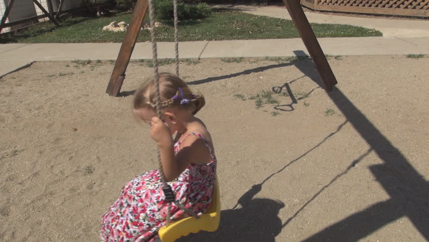 Child Swinging on a Swing Set in a Playground, Little Girl Playing in Park