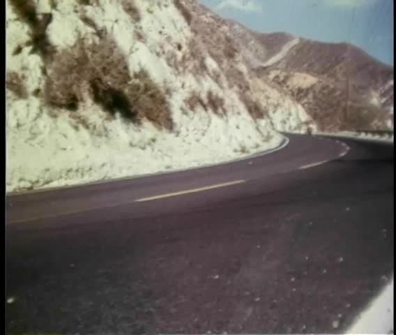 Man riding motorcycle on a winding country road