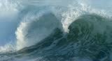 A big ocean wave crashes in slow motion on the Central Coast of California