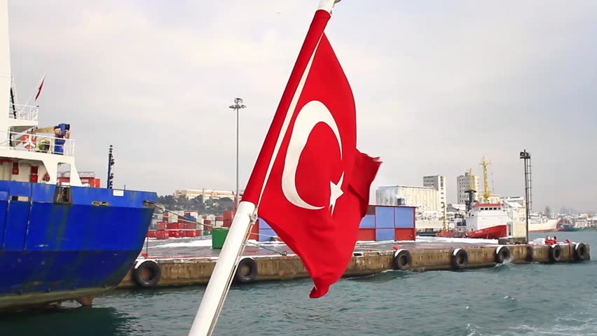 Seaport as seen from the waterside with a Turkish Flag waving. An empty container ship moored in the background. Istanbul Haydarpasa Port has a capacity of 1,200 vessels/year.
