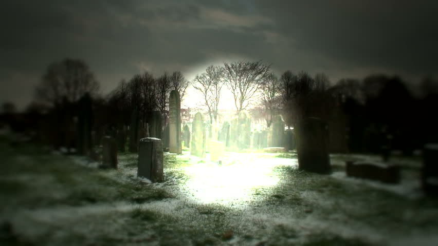 Man fades into the light in a cemetery