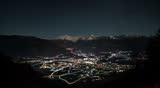Alpine night time lapse with moonrise over city. aerial view.