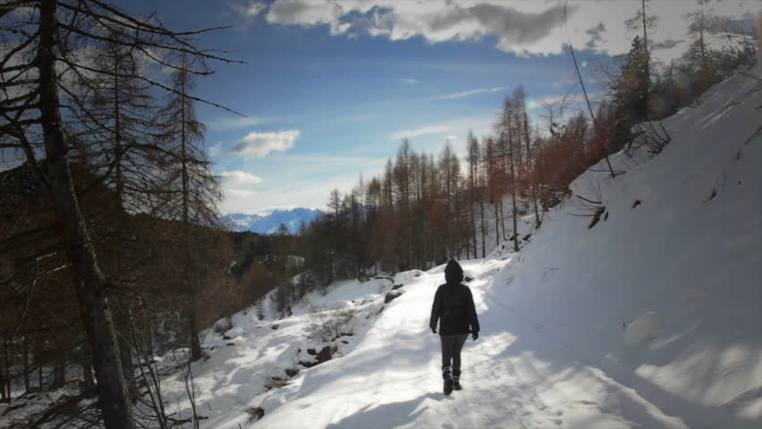 Girl walking alone on the snowy alpine mountain in winter