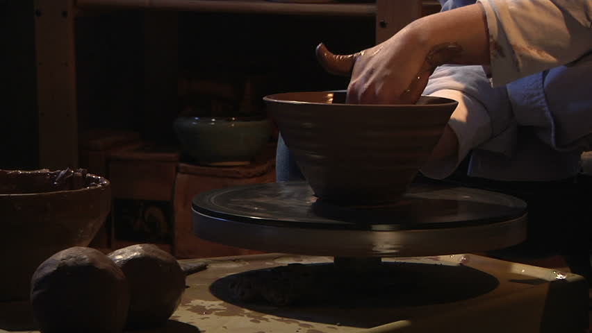 potter works with clay in ceramics studio