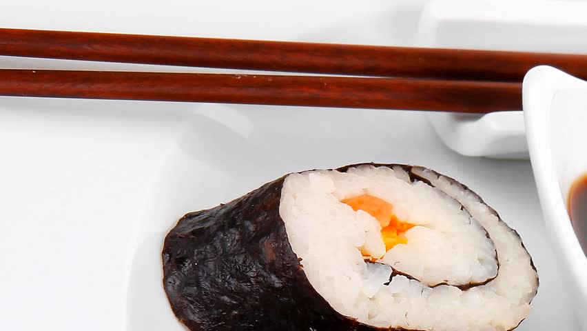 Maki Sushi : Maki Rolls and California rolls made of fresh raw Salmon(sake) Tuna(maguro) and Eel(unagi) . on white dish with sticks hidef slow motion intro