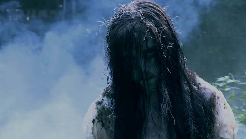 walking through fog an undead zombie girl possessed with evil attacks the camera 