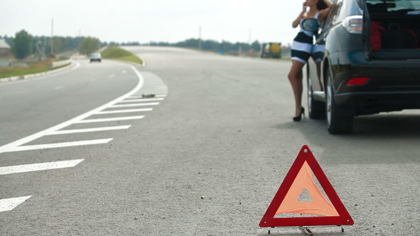 Red warning triangle with a broken down car