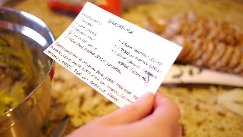 Woman refers to recipe while making guacamole