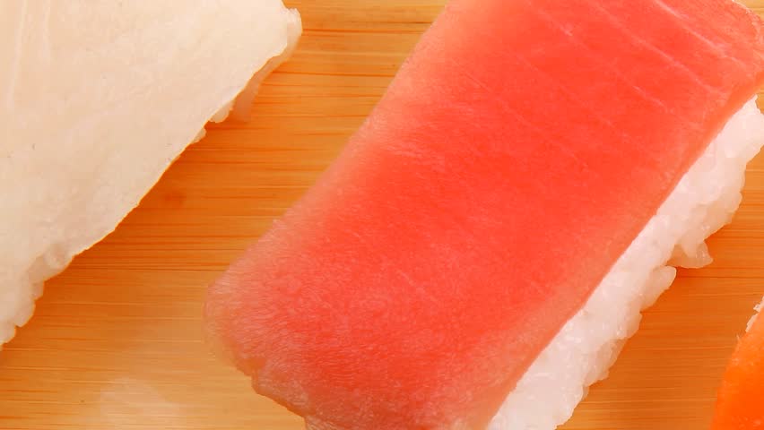 Japanese Cuisine - Set of Tuna (maguro) Salmon (sake) and Eel (unagi) Nigiri Sushi with Wasabi on wooden plate hidef intro slow motion