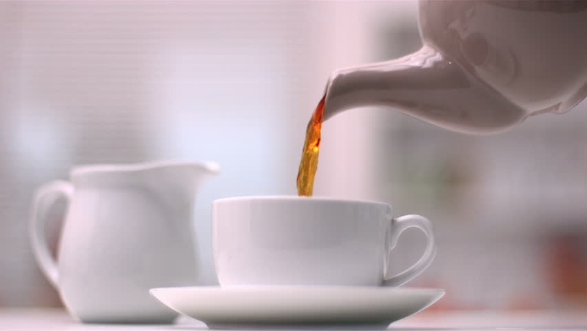 Teapot pouring tea in slow motion