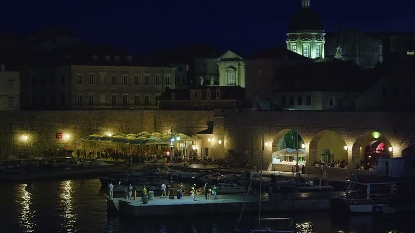 DUBROVNIK, CROATIA - SEPTEMBER 3 2012 - Summer atmosphere with tourists sightseeing and movement around restaurants in the old town harbor on September 3, 2012. in Dubrovnik, Croatia.