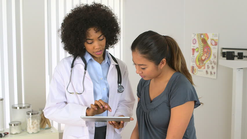 multi-racial doctor patient discuss matters on a tablet