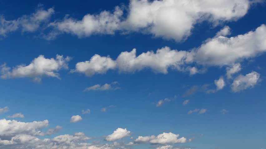 Time lapse clip of white fluffy clouds over blue sky