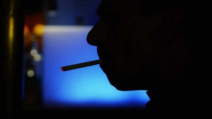 Smoking in the bar, dark depressed atmosphere and man silhouette.