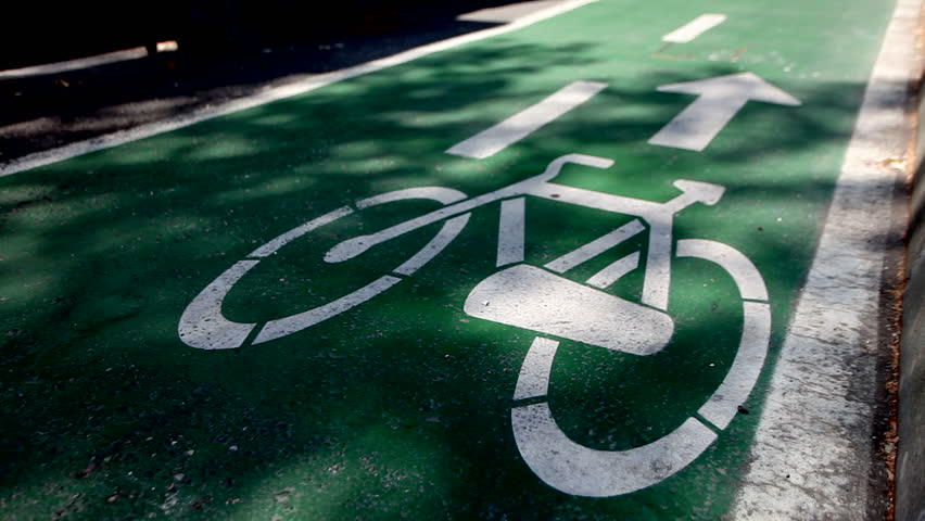 Someone is having a relaxing time riding a bike on a cycling path.
