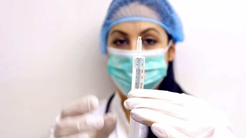 Doctor with injection ; Young doctor prepares an injection with the vaccine against influenza, video clip