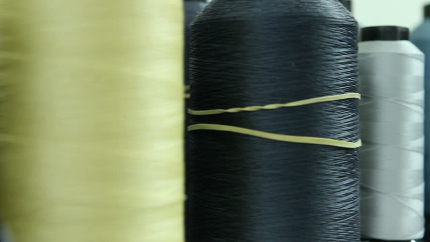Cotton thread spools in different colors, tracking shot