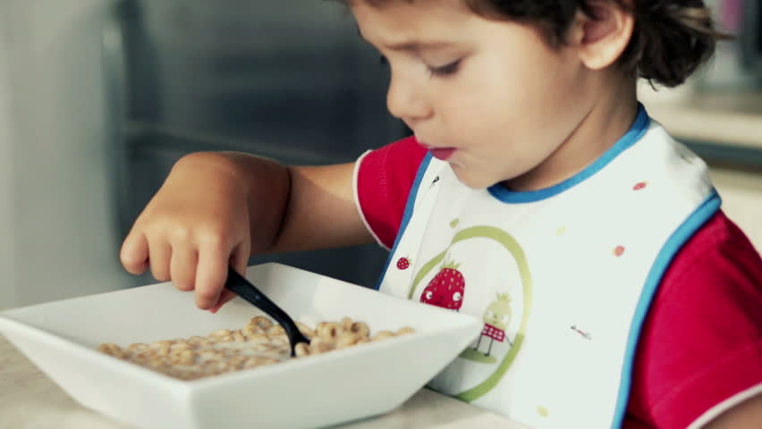 Little boy eating cornflakes with milk, slow motion shot at 120fps
