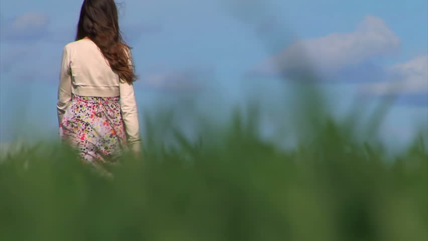 Girl Walking Away Through Tall Spring Grass